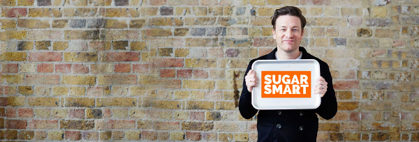 Jamie Oliver holding a tray with Sugar Smart written on it