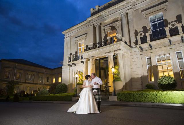 Wedded couple outside of Bath Spa Hotel at night