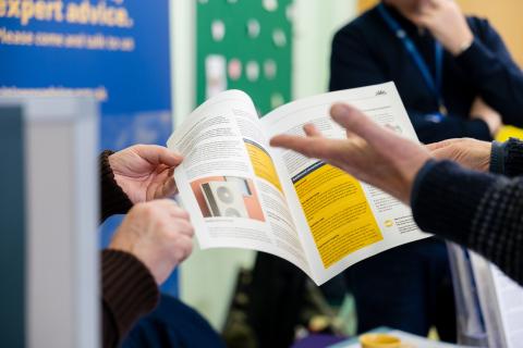 Image of a pamphlet with hands holding it open representing the concept of information and guidance