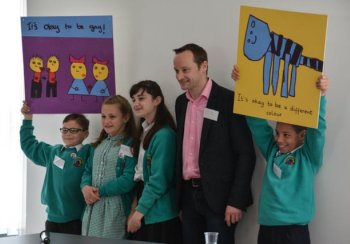 Four young people and a teacher with anti bullying posters