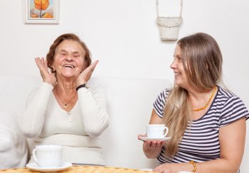 two women - one older and one younger having cuppa and chat