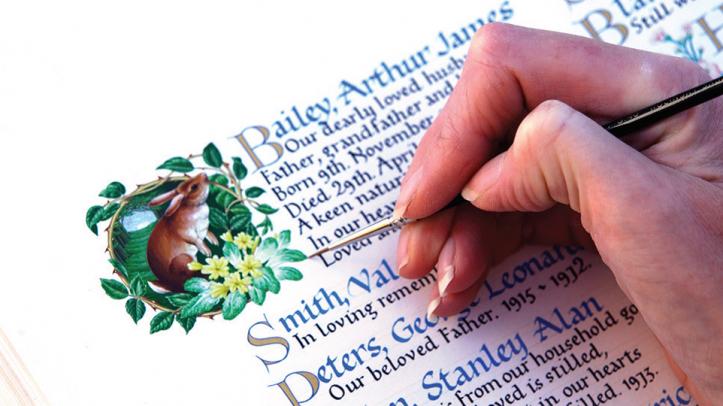 Artist painting entry in book of remembrance